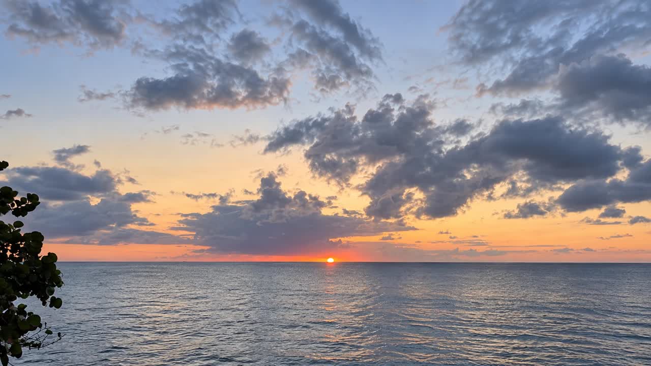 Sunlight over the ocean beneath soft clouds